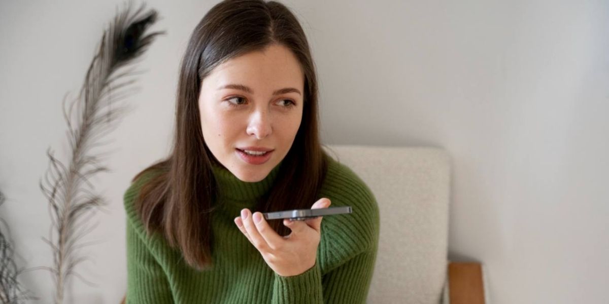 Woman in green sweater doing voice search on her phone